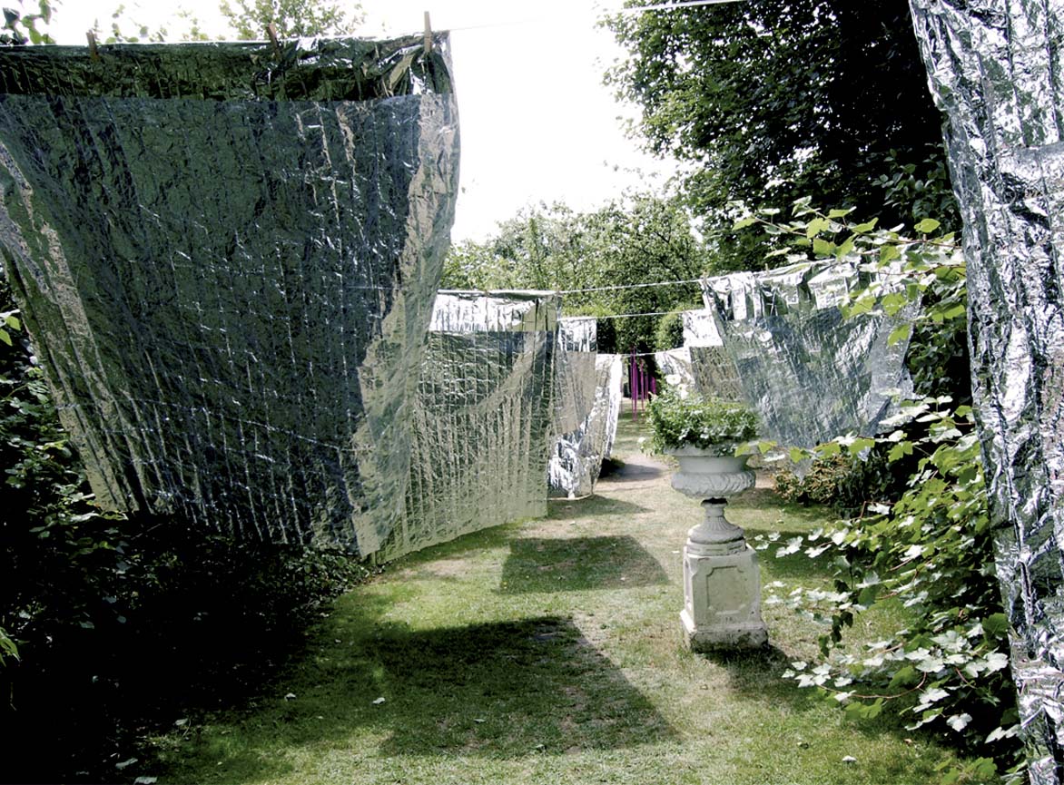'Laundry Day' Site specific environmental art installation by artist Wendy Hardie which is made of 10 emergency blankets pegged to 5 lengths of silver washing line.